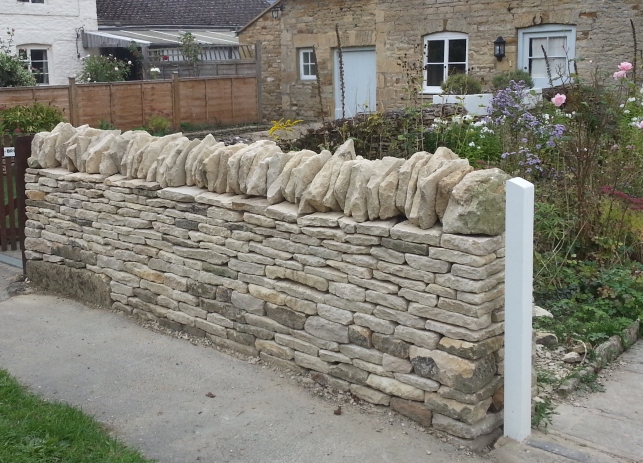 Low boundary dry stone wall in Kingham in the traditional style