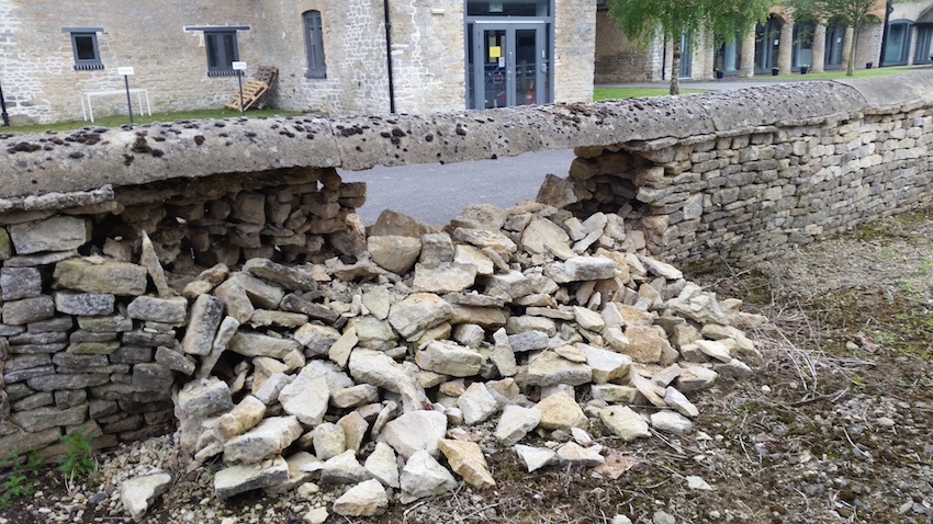 Damaged wall with hanging cement capping